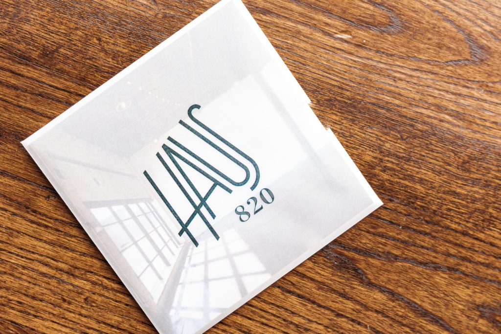 A close up view of a polished drink coaster with the Haus 820 logo