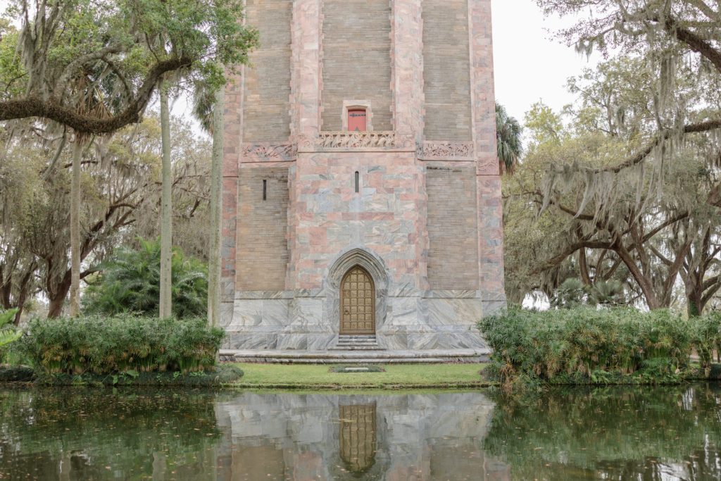 The Singing Tower in Bok Tower Gardens rises into the the distance while the serene lake fills the foreground