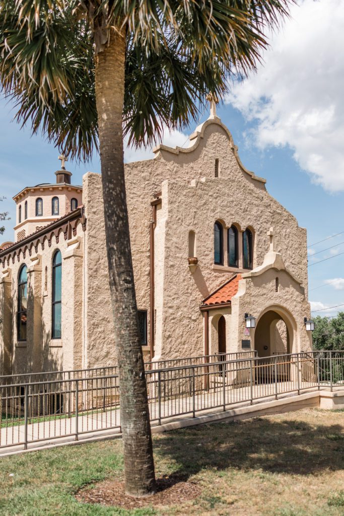 Large stucco church with ornate Spanish architectural elements. This view shows the entry to the Lake Wales wedding venue.