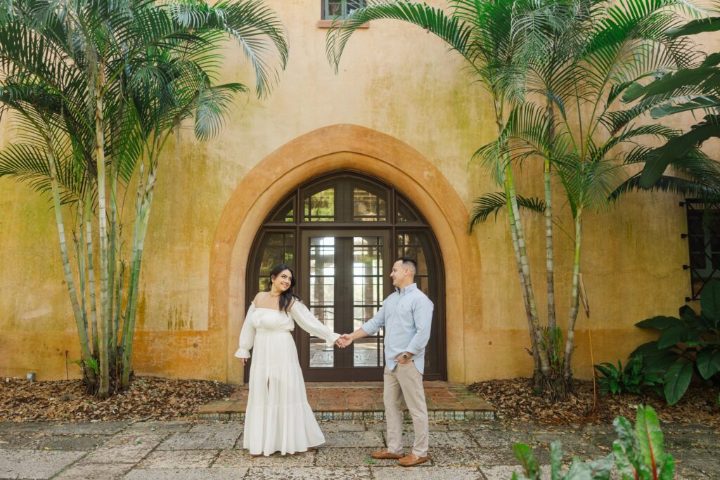 Couple in front of El Retiro's arched doors, golden stucco walls and palms