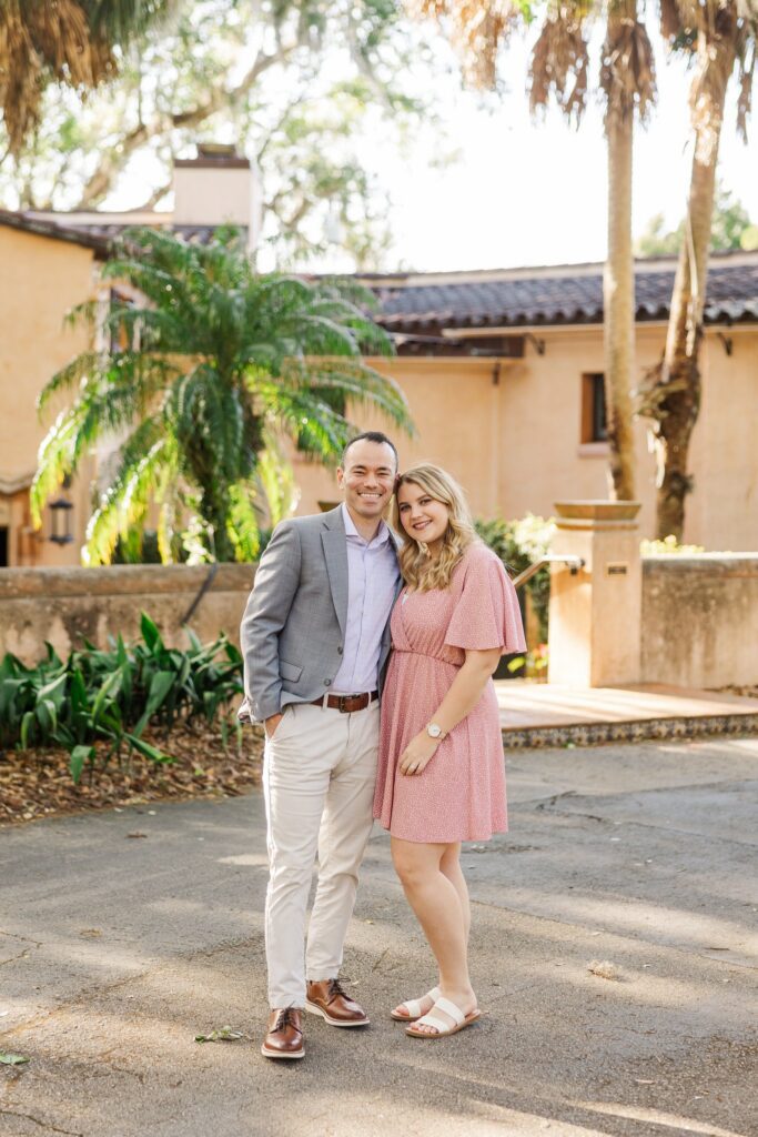 Couple standing in the El Retiro courtyard with palms and barrel tile roofs behind them