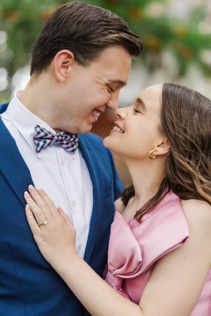 Close portrait of a couple in a pink gown and navy suit touching noses on the path near the Singing Tower