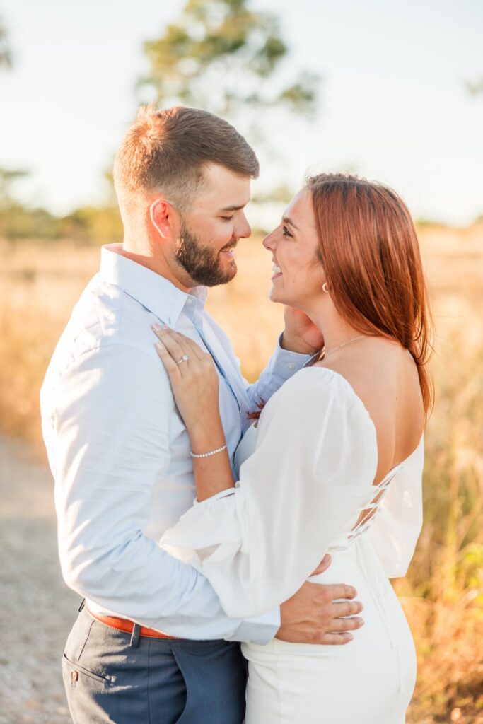 Close portrait of a couple touching noses in golden light in the pine preserve