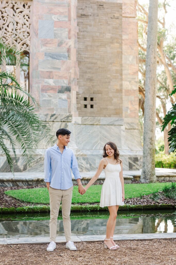 Couple holding hands beside the moat at the base of the Singing Tower